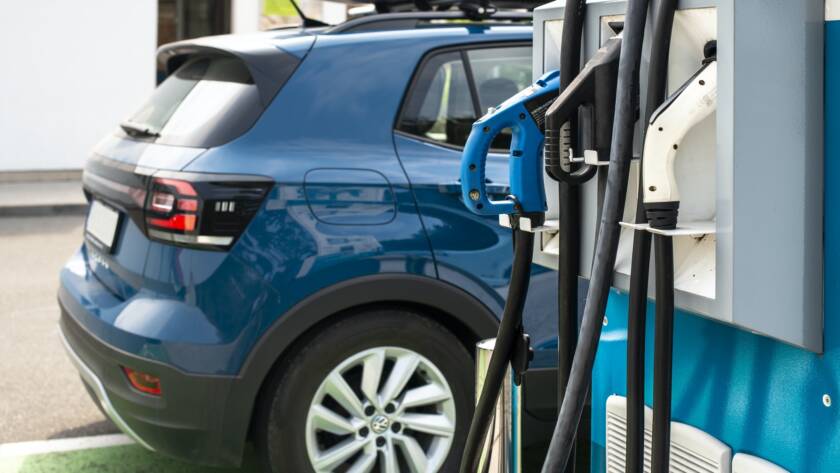 Electric car on gas station. Blue car and electric plug for char