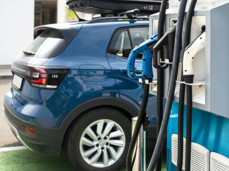 Electric car on gas station. Blue car and electric plug for char