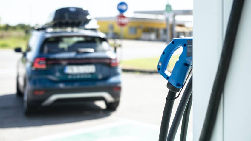 Electric car on gas station. Blue car and electric plug for char