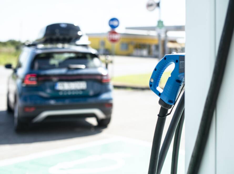 Electric car on gas station. Blue car and electric plug for char